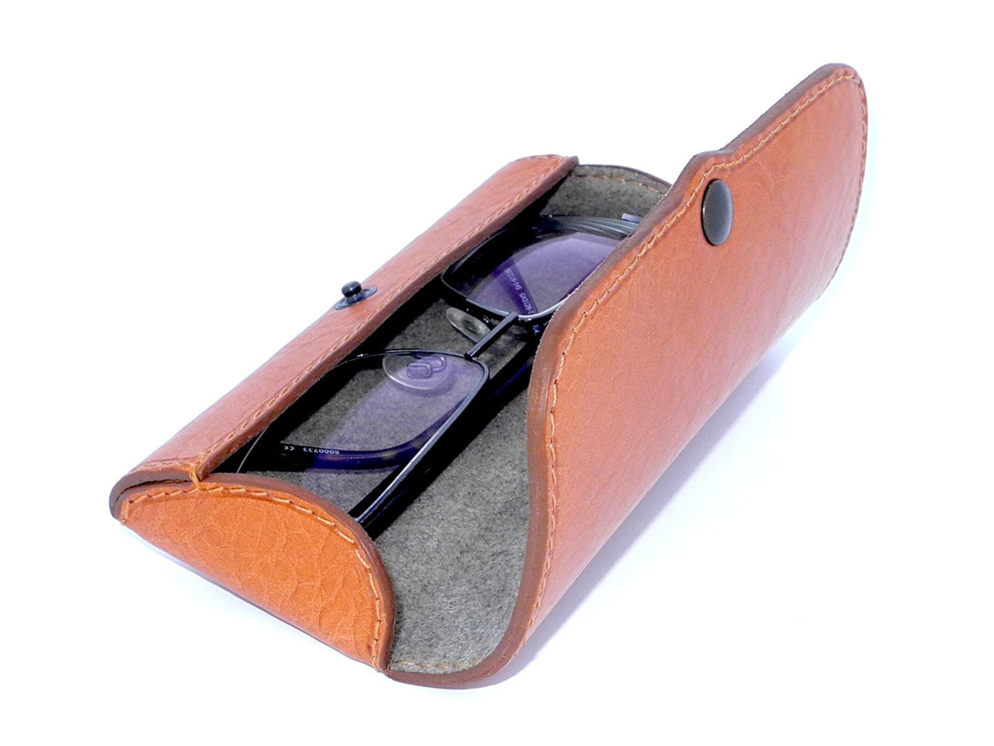 A light brown leather eyeglass case, opened and turned in semi-profile, showing a pair of glasses to show how they are included.
